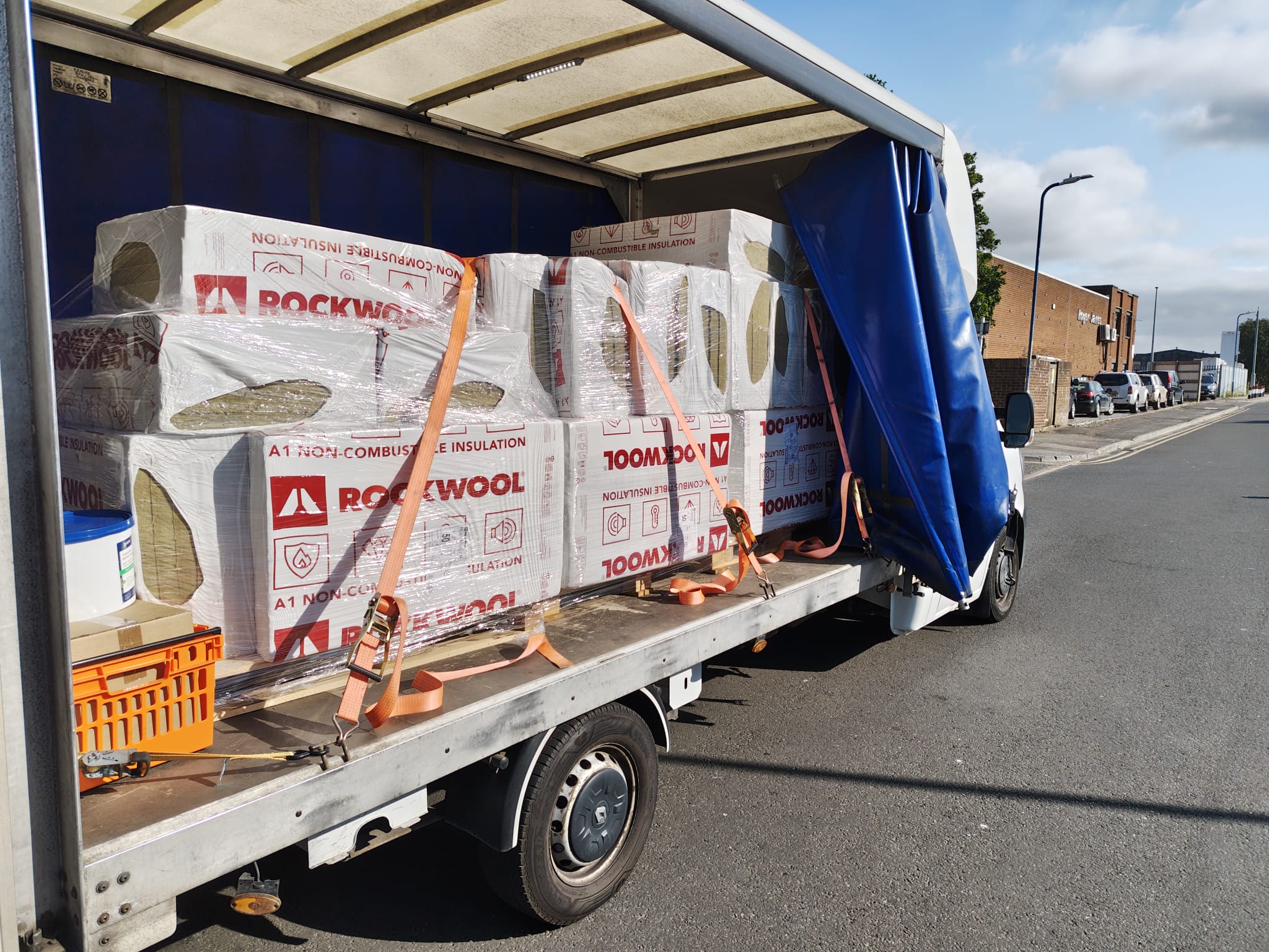 Pallets strapped to a curtainsider truck — construction site delivery